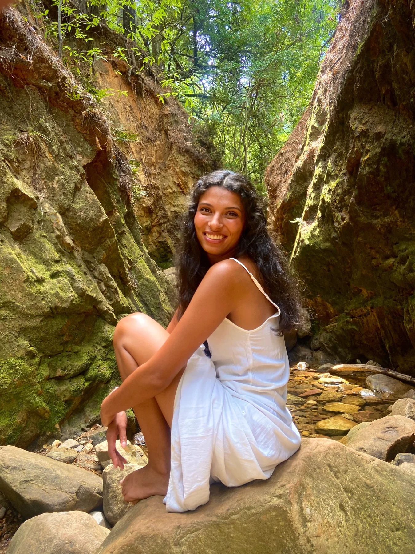 Donaë sitting among moss-covered rocks